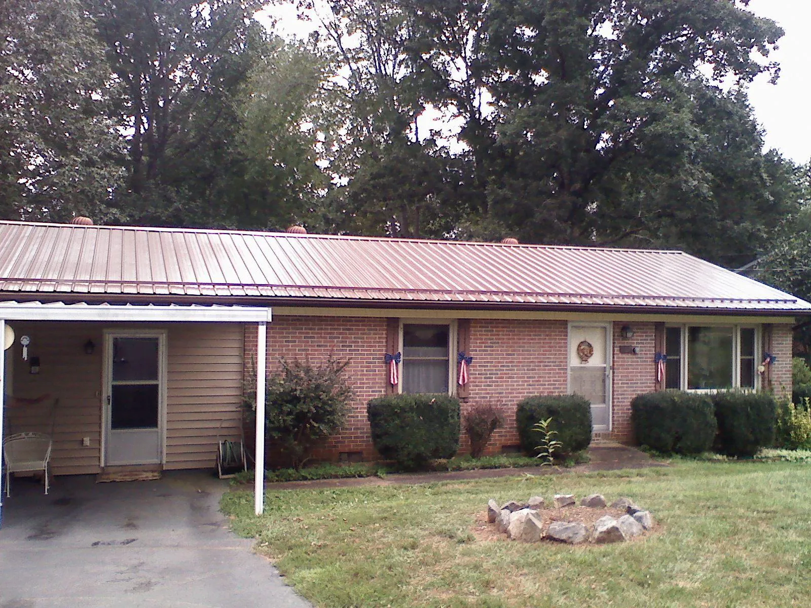 Bronze metal roof and carport on a brick ranch home — Roof Repair work by our crew in Alex